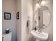 This stylish powder room features a pedestal sink, round mirror, and neutral tones for a clean, modern look at 5535 W 96Th Pl, Westminster, CO 80020