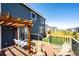 Inviting back deck with wooden pergola, porch swing, and outdoor furniture overlooking the landscaped backyard and play set at 3722 Sandy Vista Trl, Castle Rock, CO 80104
