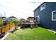 Landscaped backyard with artificial grass and a cozy wooden deck with stairs at 3722 Sandy Vista Trl, Castle Rock, CO 80104