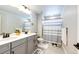 Bright bathroom featuring double sinks and a shower with striped curtain at 3722 Sandy Vista Trl, Castle Rock, CO 80104