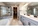 Elegant bathroom featuring double sinks, a walk-in shower, and a soaking tub at 3722 Sandy Vista Trl, Castle Rock, CO 80104