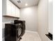 Functional laundry room with modern washer and dryer units and ample cabinet space at 3722 Sandy Vista Trl, Castle Rock, CO 80104