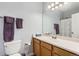 Well-lit bathroom features a neutral color palette and a classic single sink vanity with wood cabinets at 8199 Welby Rd # 3102, Denver, CO 80229