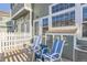 Inviting front patio features two striped chairs and a charming white picket fence for a cozy outdoor space at 8199 Welby Rd # 3102, Denver, CO 80229