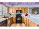 Well-lit kitchen features a black microwave and oven, light wood cabinets, and lots of counter space at 8199 Welby Rd # 3102, Denver, CO 80229