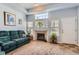 Comfortable living room with a fireplace, large windows, and a plush green sofa at 8199 Welby Rd # 3102, Denver, CO 80229