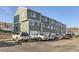 Exterior of townhouses showcasing ample parking and a well-maintained community, set against a blue sky at 8199 Welby Rd # 3102, Denver, CO 80229