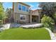 Landscaped backyard with stone accents, artificial turf, and patio area offering a great outdoor space at 24733 E Park Crescent Dr, Aurora, CO 80016