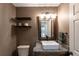 Stylish bathroom with granite countertops, vessel sink, floating shelves, and decorative mirror at 24733 E Park Crescent Dr, Aurora, CO 80016