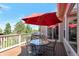 Outdoor dining area features a patio set, a barbecue and is covered by a red shade umbrella at 24733 E Park Crescent Dr, Aurora, CO 80016