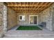 Charming covered patio features exposed wood, stone walls, with artificial turf and bench seating at 24733 E Park Crescent Dr, Aurora, CO 80016
