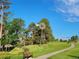 Scenic park view with a vintage windmill, walking path, bench, and lush green grass at 24733 E Park Crescent Dr, Aurora, CO 80016