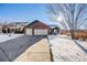 Brick home with three-car garage and snowy front yard at 10976 W 55Th Ln, Arvada, CO 80002