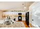 Well-equipped kitchen featuring granite countertops, white cabinetry, and black appliances at 10976 W 55Th Ln, Arvada, CO 80002