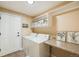 Functional laundry room with washer, dryer, and built-in shelving at 10976 W 55Th Ln, Arvada, CO 80002