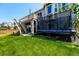 Spacious backyard with trampoline and deck area, perfect for outdoor activities and entertaining at 10221 Nucla St, Commerce City, CO 80022