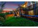 Backyard featuring a lush green lawn, a deck, stairs, and an entertaining area creating a spacious outdoor retreat at 10221 Nucla St, Commerce City, CO 80022