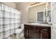 Bathroom featuring a white toilet and a dark vanity with a light countertop and a shower with a striped curtain at 10221 Nucla St, Commerce City, CO 80022