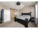 Bedroom featuring neutral walls and carpet, a wooden sliding door, and a dark wood bed frame at 10221 Nucla St, Commerce City, CO 80022