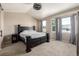 Bedroom with a dark wood bed frame, neutral walls and carpet, and lots of natural light from the bay window at 10221 Nucla St, Commerce City, CO 80022