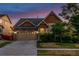 Charming exterior view of a two-story home featuring a stone and siding facade, well-maintained landscaping and driveway at 10221 Nucla St, Commerce City, CO 80022