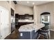 Bright kitchen with stainless appliances, an island with granite countertops, dark wood floors and lots of cabinet space at 10221 Nucla St, Commerce City, CO 80022