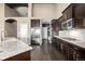 Well-lit kitchen featuring stainless appliances, an island with granite countertops, and dark wood floors at 10221 Nucla St, Commerce City, CO 80022