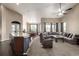 Open-concept living room featuring a ceiling fan, a grey couch, and an adjacent kitchen with a breakfast bar at 10221 Nucla St, Commerce City, CO 80022