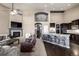 Open-concept living room with a fireplace, a large leather chair, and a kitchen with counter seating at 10221 Nucla St, Commerce City, CO 80022