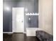 Mudroom features a gray accent wall, white door, coat hooks, and a cushioned bench at 10221 Nucla St, Commerce City, CO 80022
