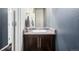 Compact powder room with a vanity featuring a light countertop and dark wood cabinets at 10221 Nucla St, Commerce City, CO 80022