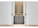Modern bar area with gray cabinets, a decorative wood accent wall, and glass door entry at 1491 S York St, Denver, CO 80210