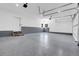 Clean three car garage with epoxy floors, white walls, and modern lighting fixtures at 1491 S York St, Denver, CO 80210