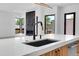 Open concept kitchen with a large island, modern sink, and black fixtures, offering ample space at 1491 S York St, Denver, CO 80210