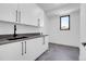 Functional laundry room with white cabinets, gray countertops, and a black faucet at 1491 S York St, Denver, CO 80210