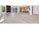 Open-concept living space featuring light hardwood floors, a modern fireplace, kitchen, and ample natural light at 1491 S York St, Denver, CO 80210
