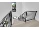 Modern staircase with black metal railings and light wood floors, illuminated by natural light from nearby windows at 1491 S York St, Denver, CO 80210