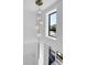 Modern stairwell featuring a contemporary chandelier and large window for natural light at 1491 S York St, Denver, CO 80210