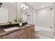Modern bathroom with double sinks, dark countertops, and an integrated shower and bathtub combination at 1426 Swan Peter Dr, Berthoud, CO 80513