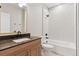 Bathroom features a modern vanity with dark countertops, wood cabinets, and tile shower and tub combo at 1426 Swan Peter Dr, Berthoud, CO 80513