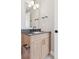 Well-lit bathroom with a modern vanity, dark countertop, sleek fixtures, and stylish light fixture above the mirror at 1426 Swan Peter Dr, Berthoud, CO 80513