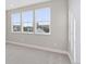 Bright bedroom featuring neutral walls, plush carpeting, and three large windows offering ample natural light at 1426 Swan Peter Dr, Berthoud, CO 80513