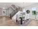 Bright dining room with modern chandelier and a staircase, adjacent to entry way and large windows at 1426 Swan Peter Dr, Berthoud, CO 80513