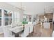 Bright dining room with modern chandelier, flows into the living room and kitchen at 1426 Swan Peter Dr, Berthoud, CO 80513