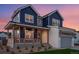 Stunning two-story home showcasing a modern design with blue siding, a white brick facade, and a welcoming front porch at 1426 Swan Peter Dr, Berthoud, CO 80513
