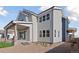 Rear view of the two-story home displaying light gray siding and a covered patio for outdoor living at 1426 Swan Peter Dr, Berthoud, CO 80513