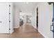 Bright and open hallway featuring hardwood floors, white walls, and a view of the staircase and living area at 1426 Swan Peter Dr, Berthoud, CO 80513