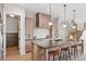 Modern kitchen features light wood cabinetry, stainless steel appliances, and a large island with seating at 1426 Swan Peter Dr, Berthoud, CO 80513
