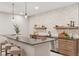 Modern basement kitchenette with a long breakfast bar, decorative backsplash, and sleek pendant lighting at 1426 Swan Peter Dr, Berthoud, CO 80513