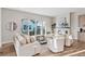 Bright living room with a fireplace, large windows, and modern neutral furniture at 1426 Swan Peter Dr, Berthoud, CO 80513